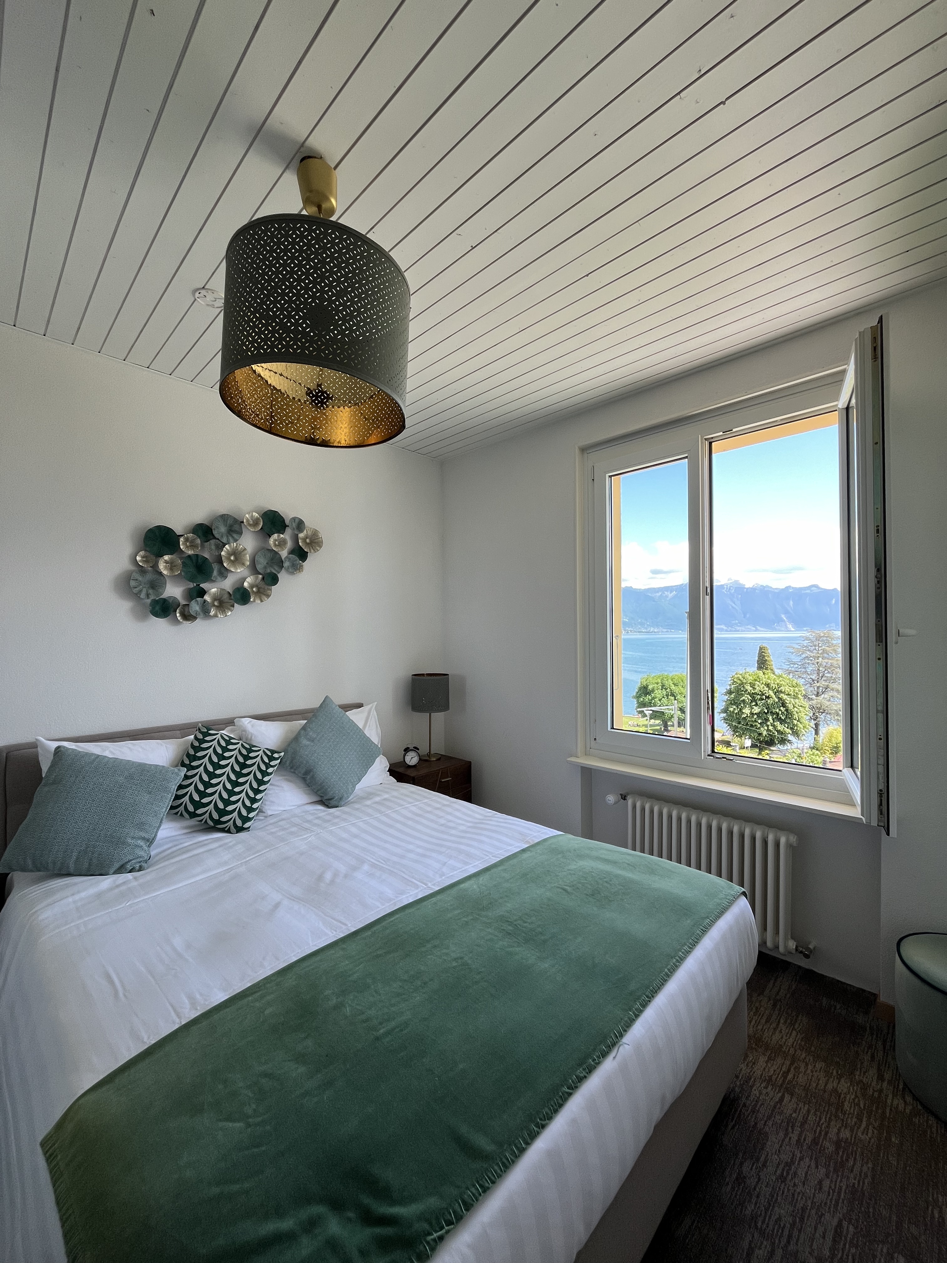 Chambre avec lit double et vue sur le lac et les montagnes