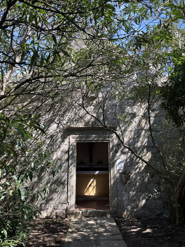 Petite chapelle en pierre cachée par des arbres