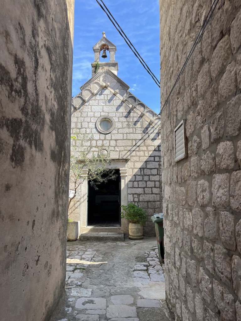 Petite chapelle en pierre entre deux maisons