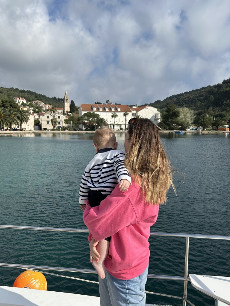 Maman et bébé qui regarde un village depuis la mer