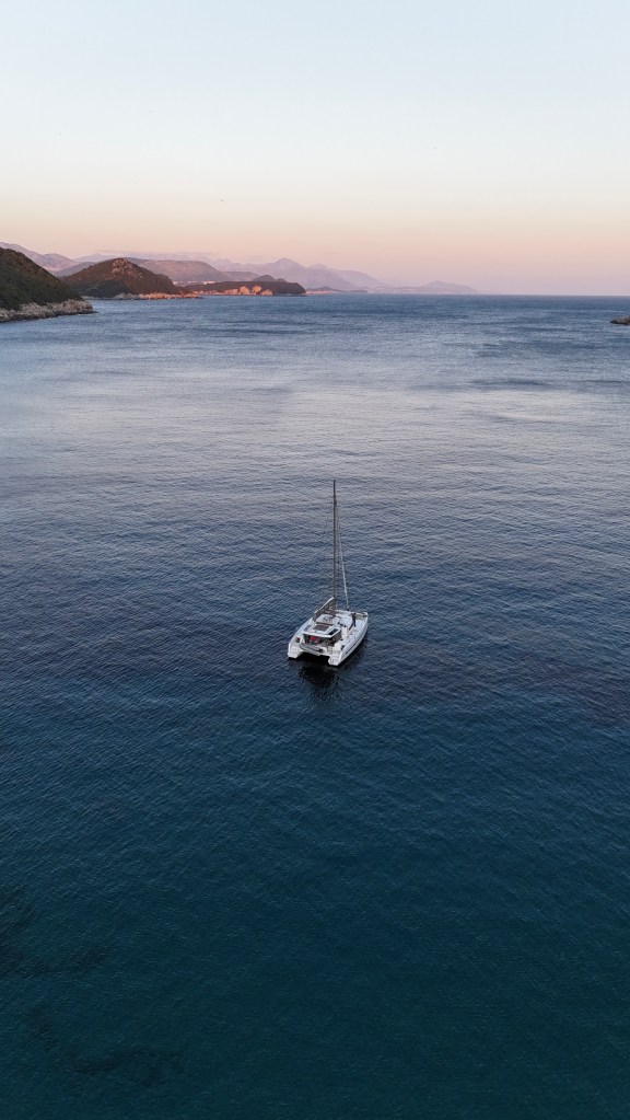 Catamaran au milieu d'une baie au coucher du soleil