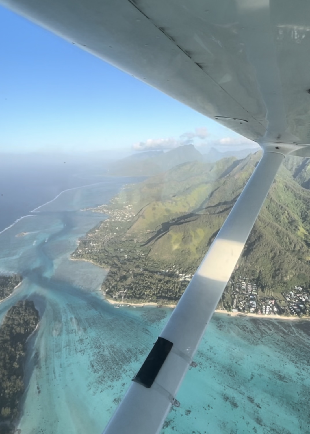 Les montagnes et le lagon de Moorea vue du ciel, et une aile d'avion