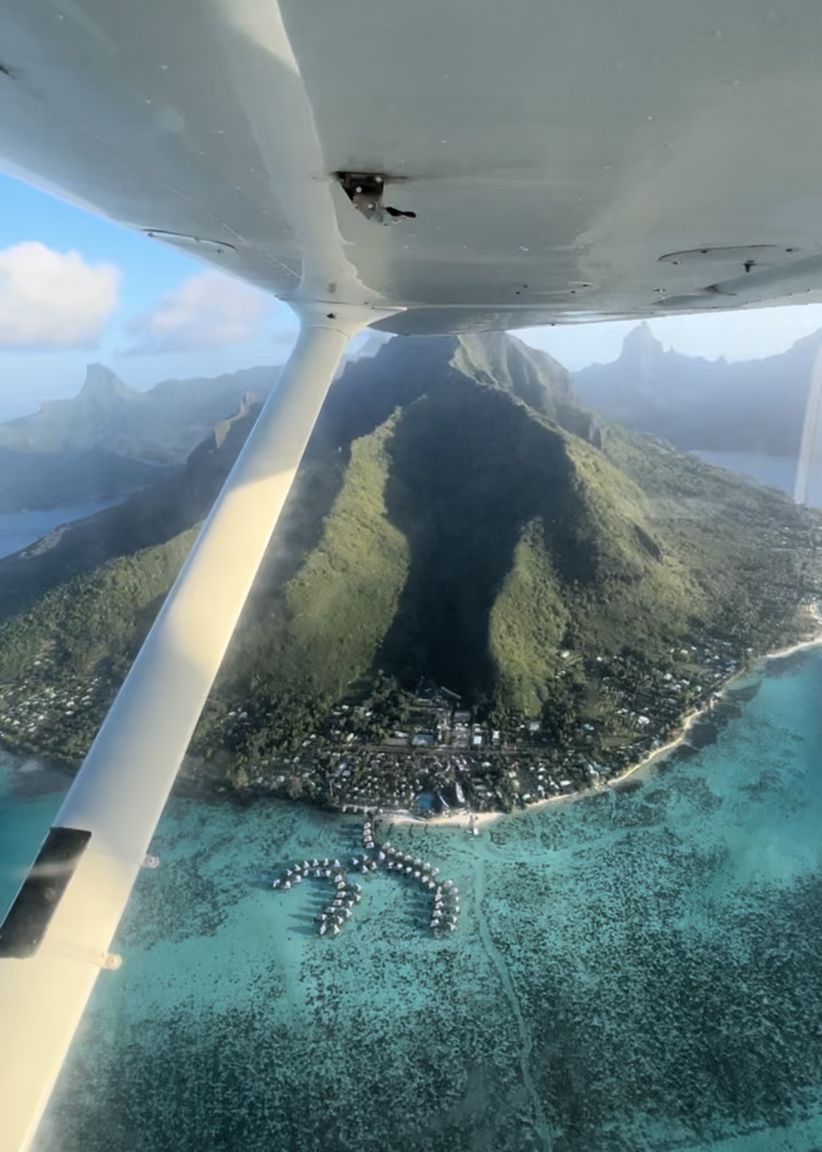 Les montagnes et le lagon de Moorea vue du ciel, et une aile d'avion