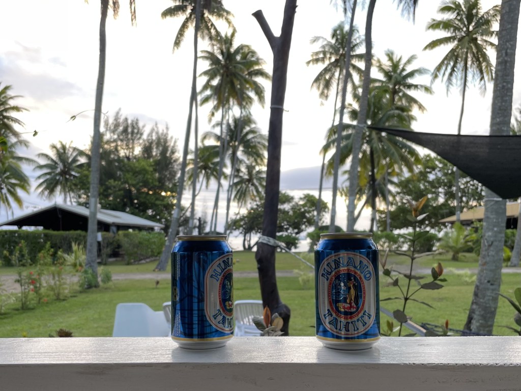 Deux canettes de bière devant des cocotiers