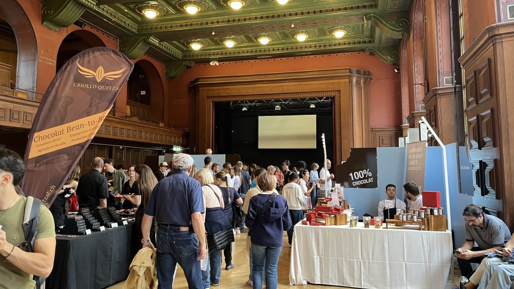 Salle boisée avec des exposants de chocolat et visiteurs